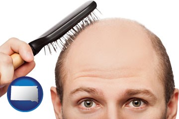 a balding man brushing his hair - with South Dakota icon